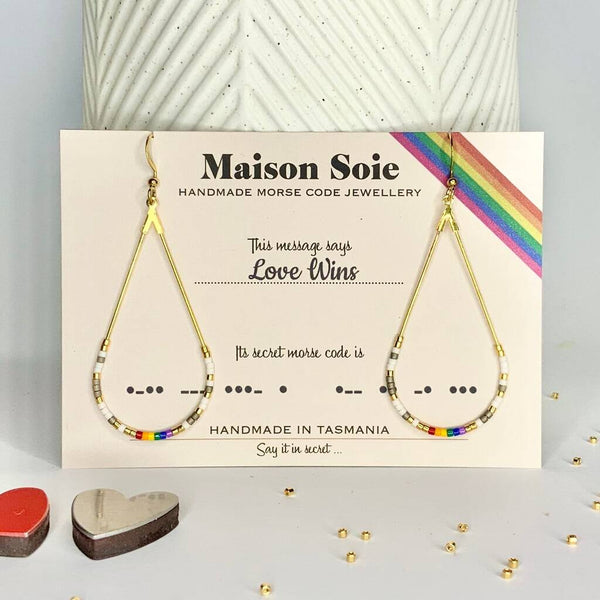 Morse Code Earrings displayed on a presentation card - the beads are arranged using Morse Code to spell out the words 'Love Wins'