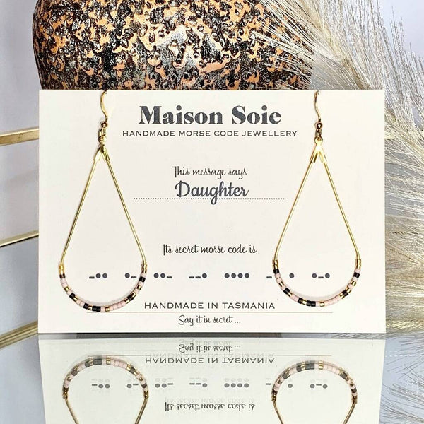 Morse Code Earrings displayed on a presentation card - the beads are arranged using Morse Code to spell out the word 'Daughter'