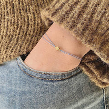 Load image into Gallery viewer, &#39;Follow Your Dreams&#39; Wish Bracelet being worn - a gold plated star shape charm is shown on a blue coloured silk thread
