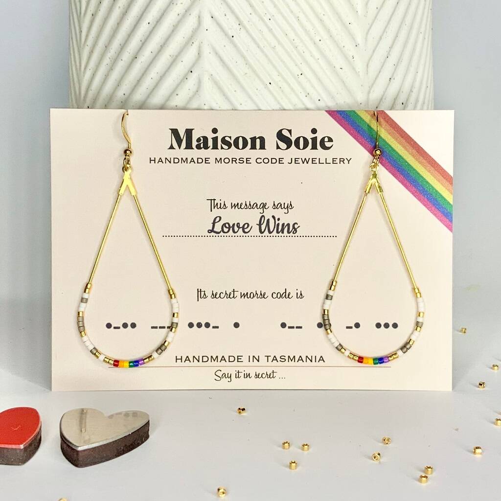 Morse Code Earrings displayed on a presentation card - the beads are arranged using Morse Code to spell out the words 'Love Wins'
