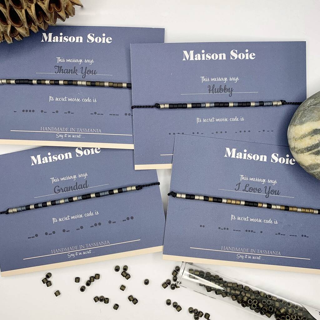 Selection of Mens Custom Made Morse Code bead bracelets displayed on cards with scattered Miyuki Beads