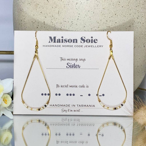 Morse Code Earrings displayed on a presentation card - the beads are arranged using Morse Code to spell out the word 'Sister'